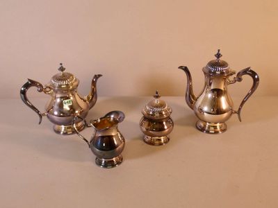 three silver teapots sitting on a table