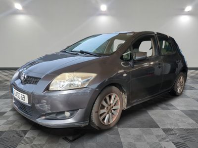 La voiture grise est garée sur le sol à damier du garage.