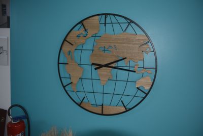 a clock on the wall that has a world map on it