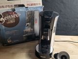 une cafetière posée sur une table à côté d'une boîte de café
