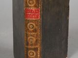 an old book sitting on top of a table next to a white wall