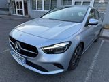 a silver mercedes cla parked in front of a building