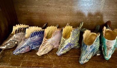 Plusieurs paires de chaussures sont alignées sur une étagère en bois