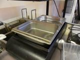 une casserole en métal posée sur une cuisinière dans une cuisine