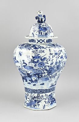 a blue and white vase with a bird on top of it