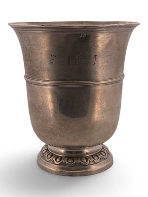 an antique silver cup on a pedestal on a white background