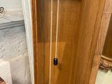 a wooden grandfather clock that is in the corner of a room