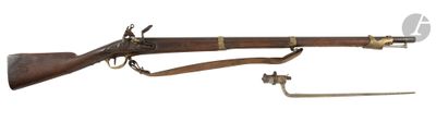 un vieux fusil avec un canon en bois et des accessoires en laiton sur fond blanc