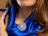 portrait of a woman in a blue dress with a brooch on her neck