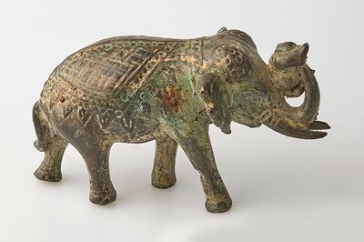 statue d'un éléphant posée sur une surface blanche, avec un fond blanc