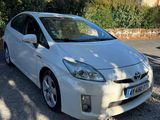 la Toyota Prius blanche garée sur un parking près d'un arbre