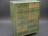 une commode verte avec des poignées en laiton sur fond gris