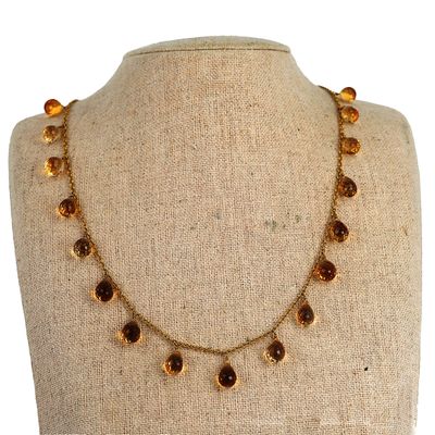 collier composé de perles de verre, présenté sur un mannequin muni d'une chaîne en or