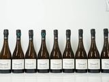 six bouteilles de vin sont alignées sur une table