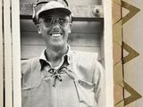 a black and white photo of a man wearing a hat and sunglasses