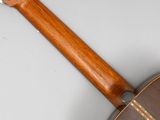 underside view of an acoustic guitar with a wooden neck and frets