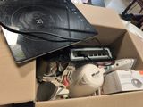 un ordinateur portable et d'autres appareils électroniques dans une boîte posée par terre