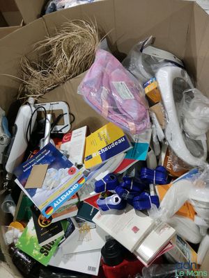 une boîte en carton remplie d'objets hétéroclites sur le sol