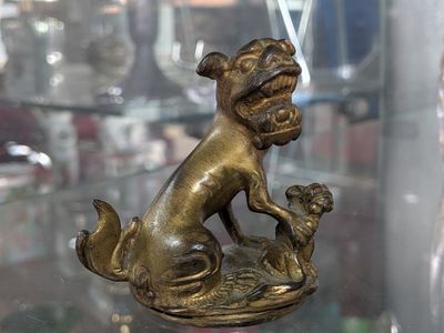 a statue of a dog sitting on top of a glass table