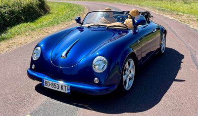 une voiture bleue qui roule sur la route avec un chien sur la banquette arrière