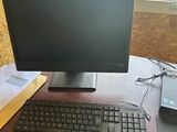 un écran d'ordinateur et un clavier posés sur un bureau devant une fenêtre