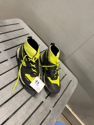 une paire de chaussures de randonnée jaunes et noires posée sur une table