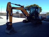 an image of a small excavator parked in a parking lot