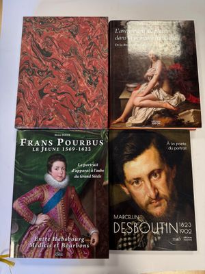 trois livres posés sur une table, dont l'un représente le portrait d'un homme et l'autre celui d'une femme