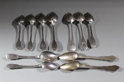 Plusieurs cuillères et fourchettes sont disposées en rangée sur une table