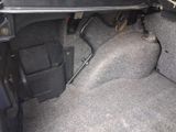 the interior of a car with the door open and the floor covered in carpet