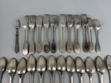 a lot of silver spoons and forks on the table