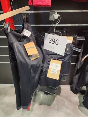 trois vestes suspendues à un portant dans un magasin