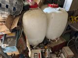 two large white tanks sitting on top of a pile of junk