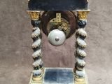a clock that is sitting on a stand on the floor