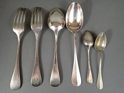 cinq cuillères en argent et deux cuillères en argent sur une table