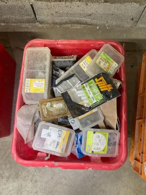 a red container filled with assorted items next to a red trash can