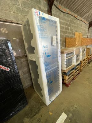a refrigerator that is sitting in a warehouse next to pallets