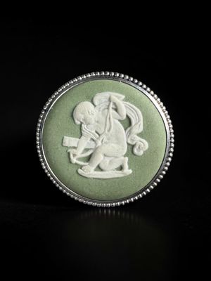 a close up of a ring on a black surface with a picture of a man riding a horse