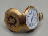 une petite montre de poche en or sur laquelle figure une horloge