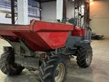 a red tractor that is parked inside of a building