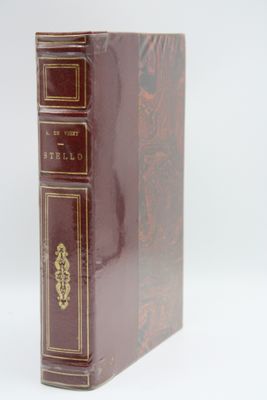 an old book sitting on top of a white table next to a white wall