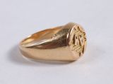 a close up of a gold signet ring on a white surface