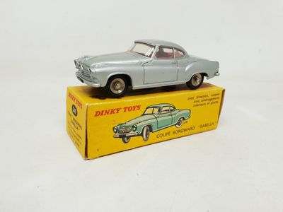 an old toy car sitting on top of a box on a white surface