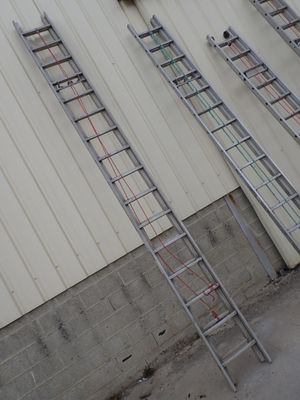 several ladders are leaning against a wall in front of a building
