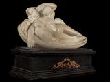 an image of a statue of a woman laying on top of a marble base