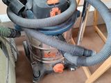 a vacuum that is sitting on the floor next to a chair