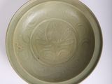 a green bowl with a design on it on a white surface