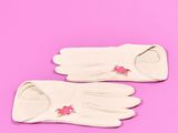 une paire de gants blancs sur fond rose