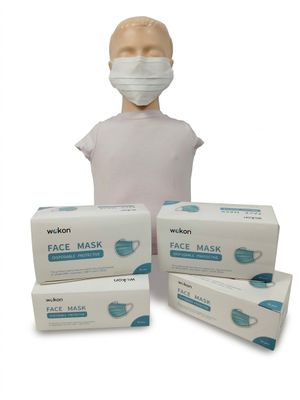 trois boîtes de masques faciaux et une tête de mannequin sur fond blanc