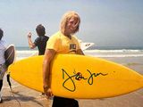 un homme qui tient une planche de surf sur la plage